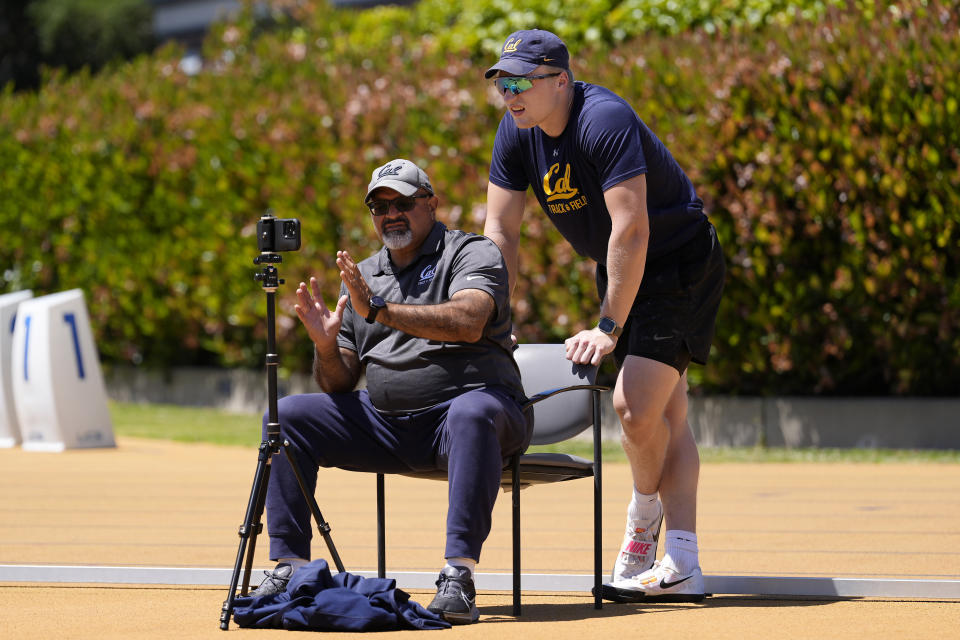 California track and field coach Mohamad Saatara, left, reviews a video with Mykolas Alekna during practice in Berkeley, Calif., Thursday, May 2, 2024. (AP Photo/Jeff Chiu)