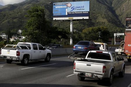 Motorists drive past a campaign billboard urging commuters to vote for MIN Unidad Party in Caracas, November 3, 2015. REUTERS/Marco Bello