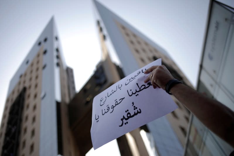 A demonstrator holds a sign in front of Alfa headquarters during a protest in Beirut