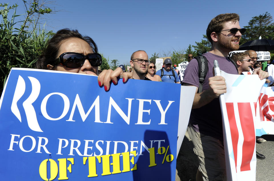 Protestors from MoveOn.org, the Occupy Movement and the Long Island Progressive march down Meadow Lane during a demonstration against a fundraiser for Republican presidential candidate Mitt Romney at the home of industrial billionaire David H. Koch on Sunday, July 8, 2012, in Southampton, N.Y. Romney would be among the nation's richest presidents if elected. He made his fortune at Bain Capital, a Boston-based private equity. (AP Photo/Kathy Kmonicek)