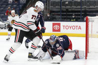 Columbus Blue Jackets' Elvis Merzlikins, right, makes a save against Chicago Blackhawks' Kirby Dach during the first period of an NHL hockey game Saturday, April 10, 2021, in Columbus, Ohio. (AP Photo/Jay LaPrete)