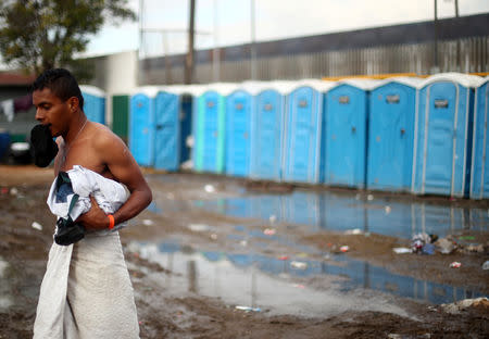 A migrant, part of a caravan of thousands from Central America trying to reach the United States, walks through a temporary shelter in Tijuana, Mexico, November 28, 2018. REUTERS/Hannah McKay