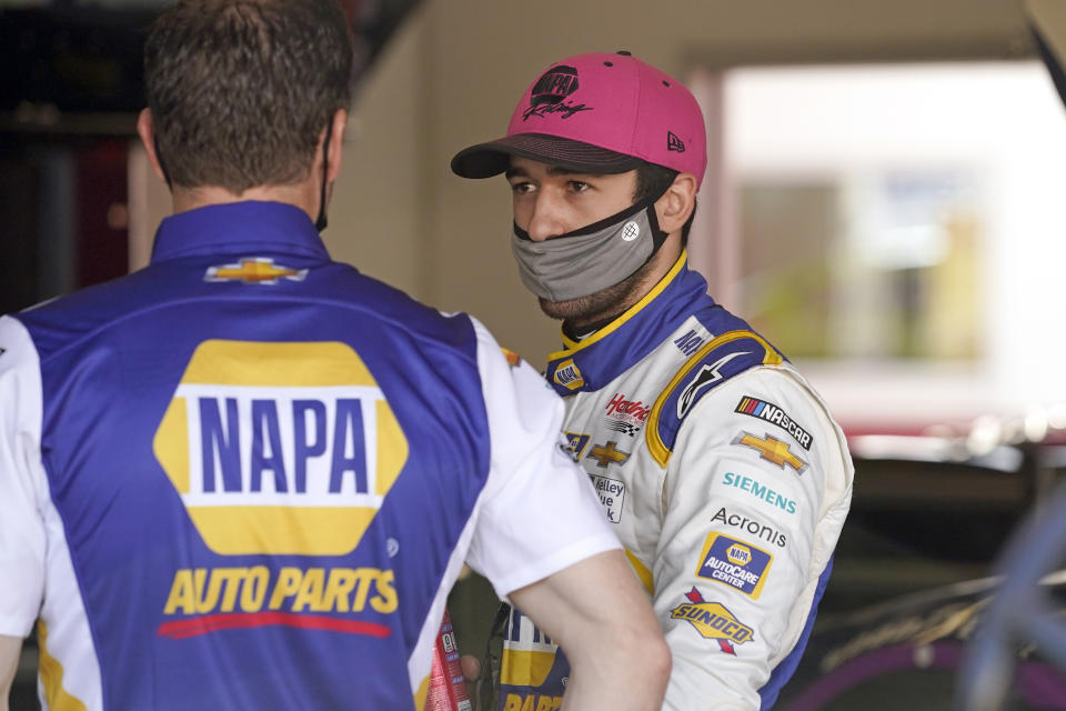 Chase Elliott, right, talks with a crew member in his garage during a NASCAR Daytona 500 auto race practice session at Daytona International Speedway, Wednesday, Feb. 10, 2021, in Daytona Beach, Fla. (AP Photo/John Raoux)