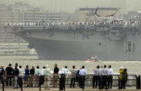 People watch the USS Wasp sail up the Hudson River from Jersey City, N.J., Wednesday, May 23, 2012. Naval vessels ranging from a U.S. amphibious assault ship to a Finnish minelayer are participating in New York City's Fleet Week. (AP Photo/Seth Wenig)