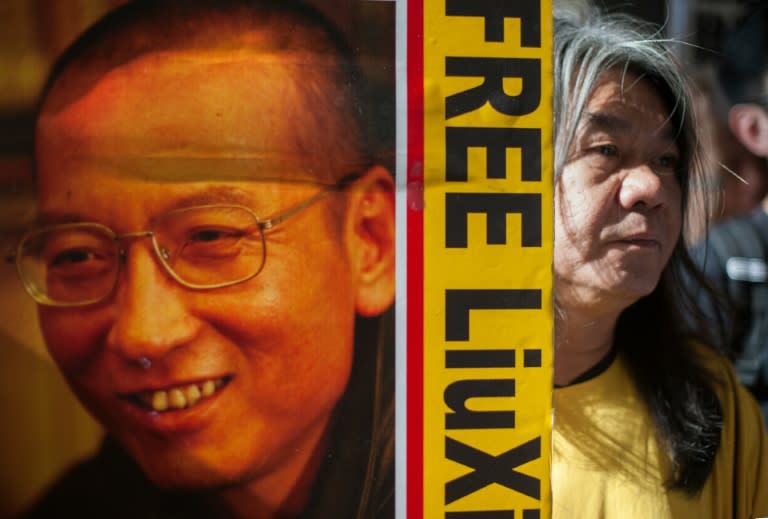 Hong Kong activist and legislator Leung Kwok-hung (R), popularly known as "Long Hair", holds a placard calling for the release of Chinese human rights activist Liu Xiaobo during a protest in Hong Kong on May 18, 2016