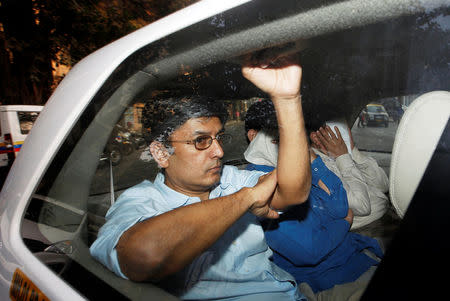 FILE PHOTO - Men suspected of steering fraudulent loans to companies linked to billionaire jeweller Nirav Modi sit inside a police vehicle as they leave a court in Mumbai, India February 21, 2018. REUTERS/Francis Mascarenhas