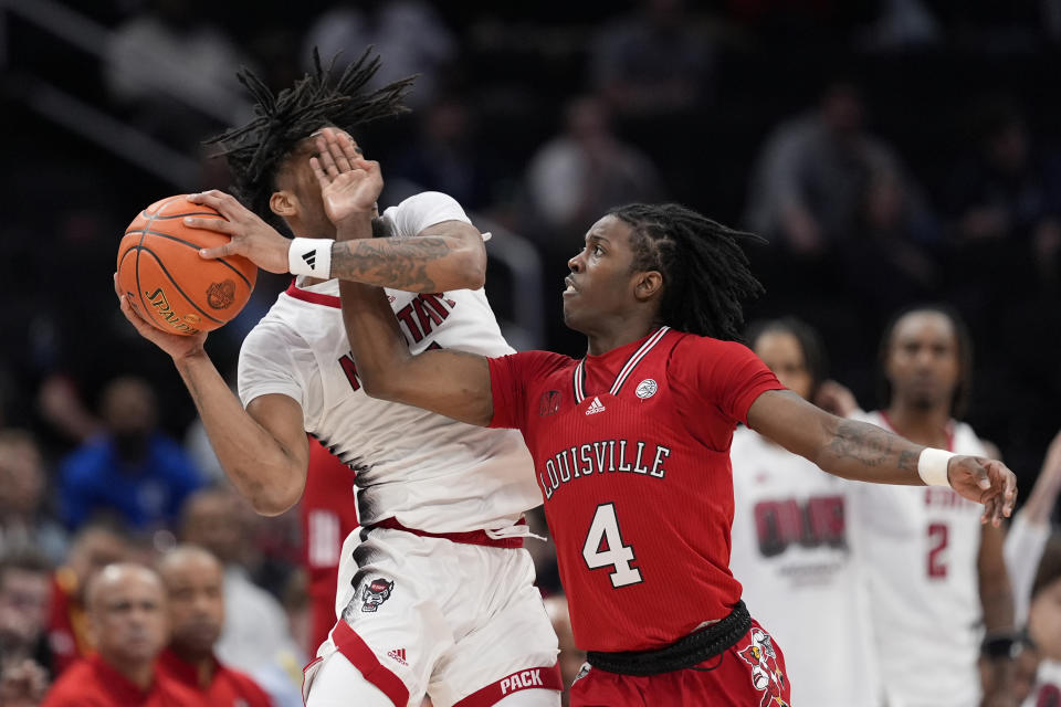 North Carolina State guard Jayden Taylor (1) goes up against Louisville guard Ty-Laur Johnson (4) during the second half of the Atlantic Coast Conference NCAA college basketball tournament Tuesday, March 12, 2024, in Washington. (AP Photo/Susan Walsh)