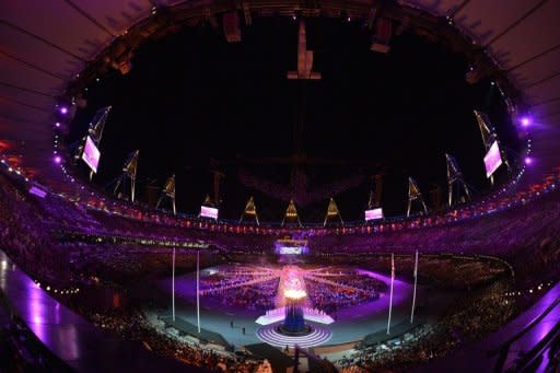 This picture shows a general view with the Olympic flame in the foreground during the closing ceremony of the 2012 London Olympic Games at the Olympic stadium in London