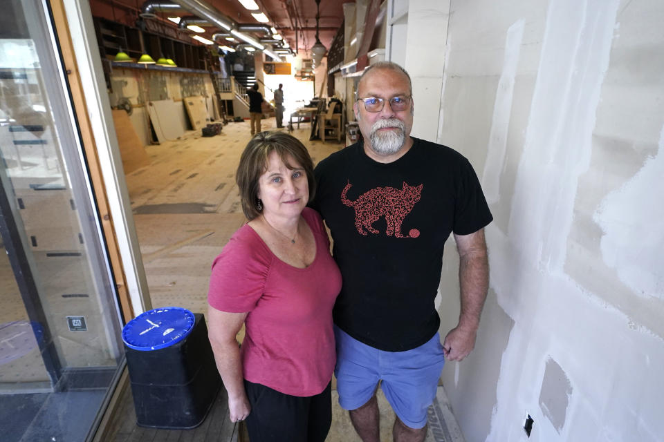 Bear Pond Books owners Claire Benedict, left, and Rob Kasow, pose in their shop, which is being rebuilt following the July flooding, Tuesday, Aug. 1, 2023, in Montpelier, Vt. Vermont's flooding was just one of several major flood events around the globe this summer that scientists have said are becoming more likely due to climate change. "I think now we’ve been a little disabused of the notion that Vermont is safe from climate change,” Kasow said. (AP Photo/Charles Krupa)