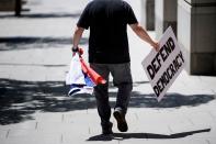 <p>A protester carrying a Russian flag leaves after the bail of former Trump campaign chairman Paul Manafort was revoked during a hearing at federal court June 15, 2018 in Washington, D.C. (Photo: Brendan Smialowski/AFP/Getty Images) </p>