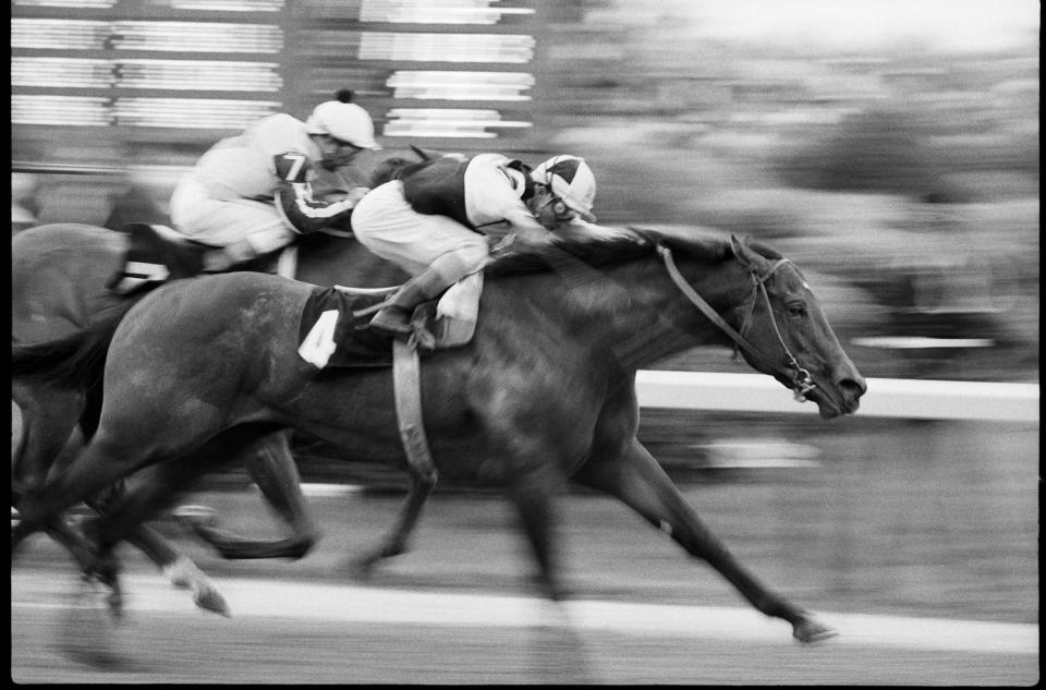 Foolish Pleasure, with jockey Jacinto Vasquez aboard, surges ahead to take the lead to win the Kentucky Derby in 1975.
