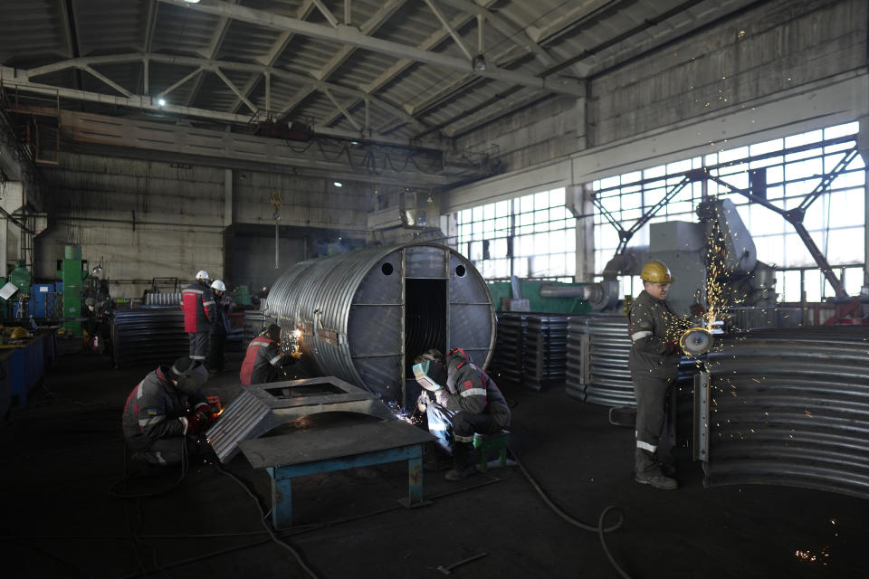 Workers weld and cut metal as they build a shelter in a plant of Metinvest company, in Kryvyi Rih, Ukraine, Thursday, March 2, 2023. The plant, which is part of Renat Akhmetov's Metinvest metals and mining holding, ships metal shelters to frontline. (AP Photo/Thibault Camus)