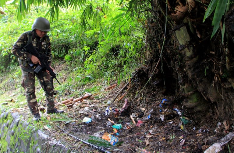 A soldier scours the site of a roadside blast in Marawi last November -- the the twon is believed to be the hiding place of a leader of Abu Sayyaf