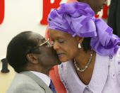 <p>Mugabe kisses his wife, Grace, at his 80th birthday party in his home area of Zvimba, Feb. 21, 2004. Mugabe celebrated his 80th birthday one day after indicating that he would retire within five years amid a deepening political and economic crisis. (Photo: Howard Burditt/Reuters) </p>