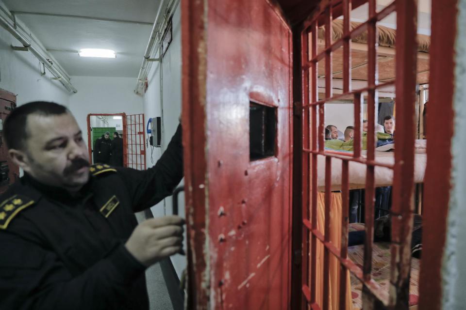 In this photo taken on Tuesday, Jan. 31, 2017, chief prison commissioner Cristian Micu, closes a cell door at the Jilava prison, in Jilava, Romania. Romania's government decriminalized official misconduct overnight Wednesday Feb. 1, 2017, defying mass protests and warnings from prosecutors and the president that the move will reverse the country's fight against corruption. (AP Photo/Vadim Ghirda)