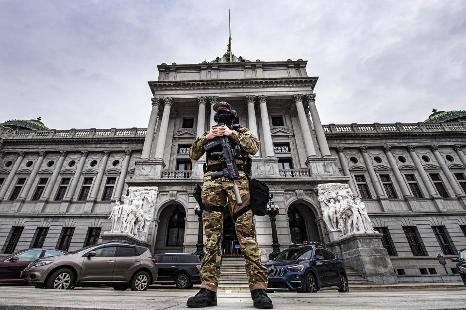 A member of the Pennsylvania Capitol Police stands guard at the entrance to the Pennsylvania Capitol Complex in Harrisburg, Pa., Wednesday, Jan. 13, 2021. State capitols across the country are under heightened security after the siege of the U.S. Capitol last week. (Jose F. Moreno/The Philadelphia Inquirer via AP)