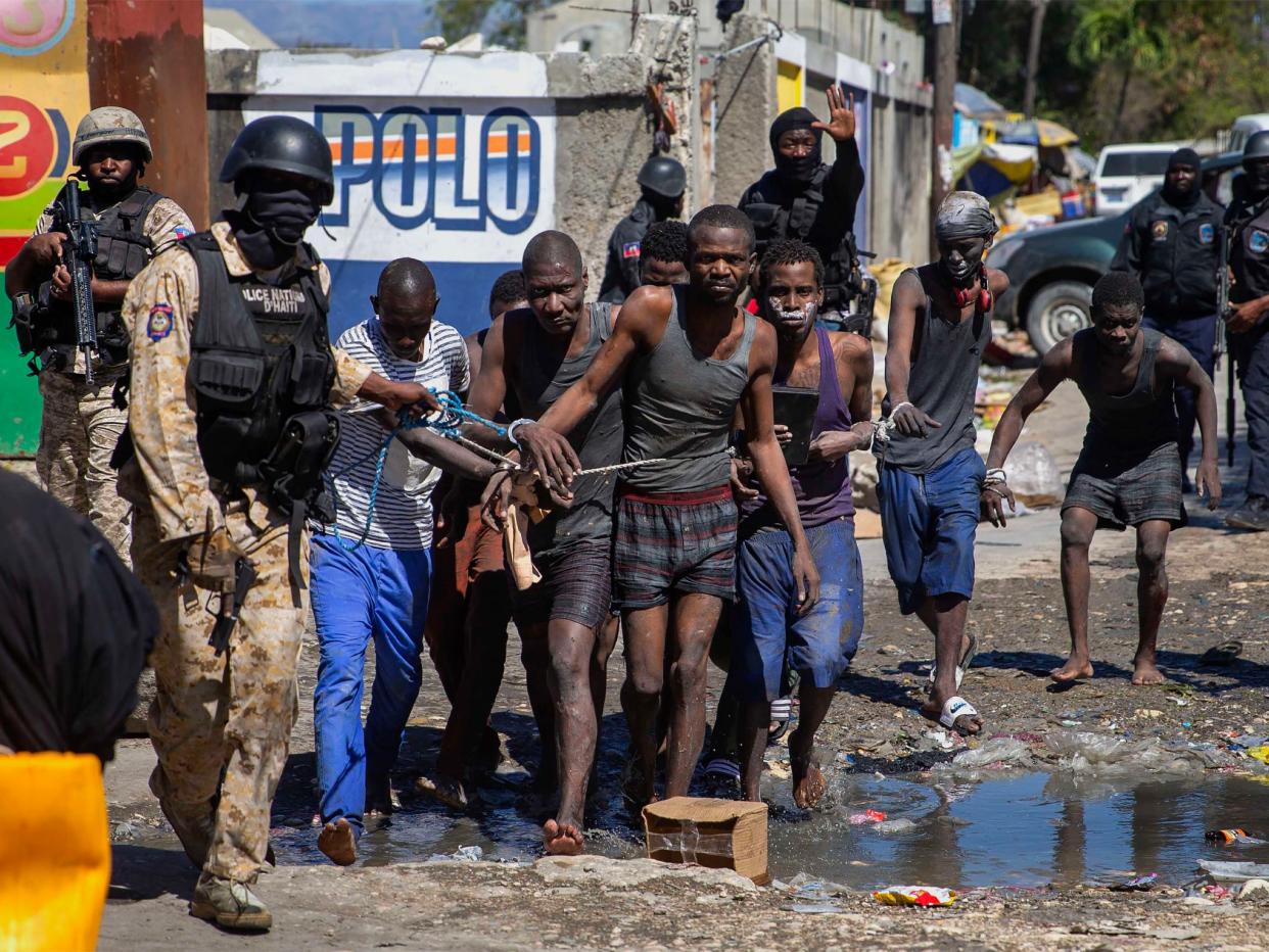 <p>Recaptured inmates led by police outside the Croix-des-Bouquets Civil Prison</p> (AP)