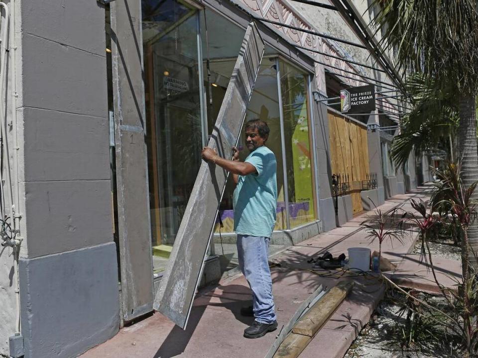 Employee Martin Zelaya takes down the shutters at The Frieze Ice Cream Factory employee after Hurricane Irma in 2017.