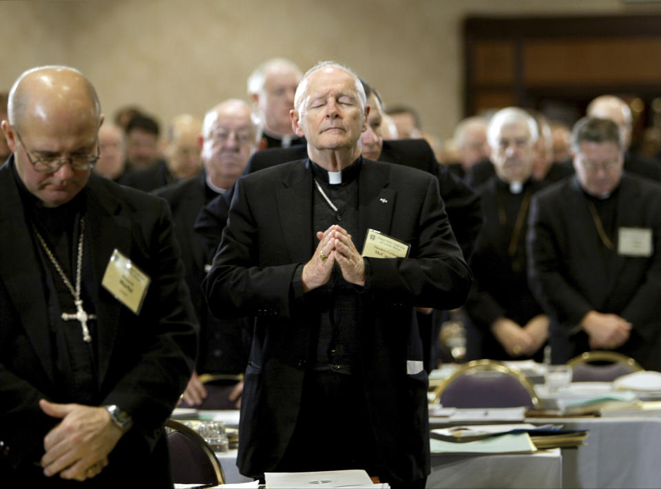 FILE - In this Nov. 10, 2003 file photo, Cardinal Theodore Edgar McCarrick, Archbishop of Washington, D.C., center, joins fellow clergy in prayer at the end of the opening session of the U.S. Conference of Catholic Bishops meeting in Washington. McCarrick – who was defrocked by Pope Francis in 2019 – served as head of Catholic dioceses in Metuchen and Newark, New Jersey, and in Washington. A report released by the Vatican on Monday, Nov. 9, 2020, found that three decades of bishops, cardinals and popes dismissed or downplayed reports of McCarrick’s misconduct with young men. (AP Photo/J. Scott Applewhite, File)