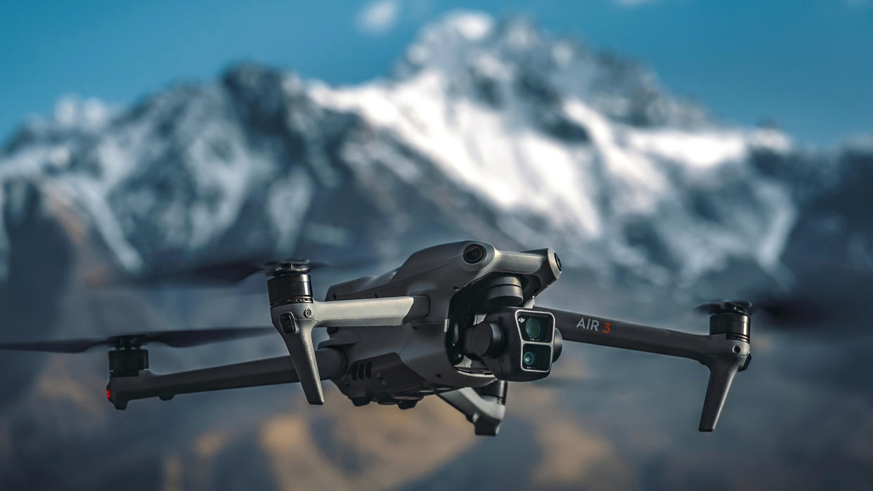  DJI Air 3 drone in flight with snow capped mountain background. 