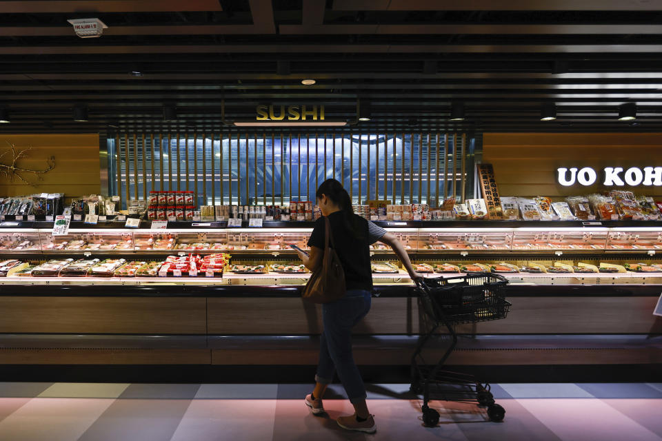 A customer shops at a supermarket for sushi and sashimi, some of which are labeled as from Japan, in Hong Kong, on Thursday, Aug. 24, 2023. The Hong Kong authorities have imposed a ban on imports of Japanese seafood as a gesture to oppose Japan's decision to discharge the treated radioactive water from the wrecked Fukushima nuclear power plant. (AP Photo/Daniel Ceng)