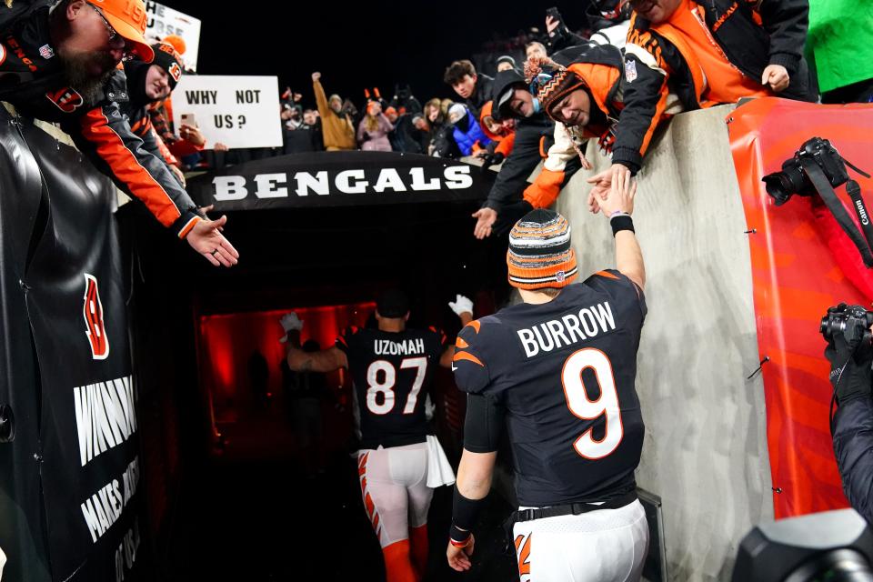 Cincinnati Bengals quarterback Joe Burrow (9) high fives fans coming off the field at the conclusion of the fourth quarter during an NFL AFC wild-card playoff game, Saturday, Jan. 15, 2022, at Paul Brown Stadium in Cincinnati.  The Cincinnati Bengals defeated the Las Vegas Raiders, 26-19 to win the franchise's first playoff game in 30 years.