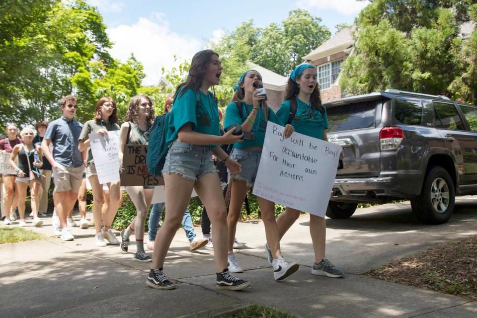 Aiden Finnell (left), Grace Morton (center), Lily Russell (right), lead the crowd while chanting for the removal of Myers Park administration during the protest against sexual assault on Tuesday, June 29, 2021.