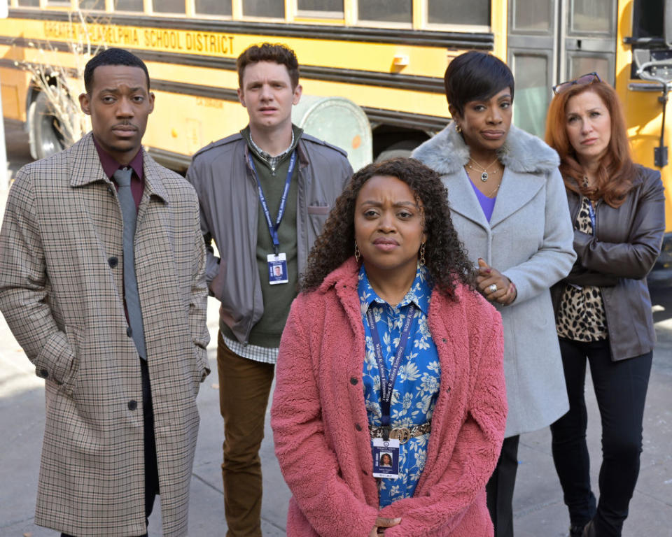 the cast of abbott elementary on set in the pilot episode, standing outside the school