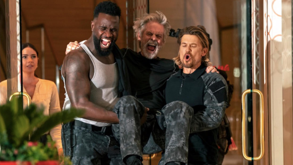  Terrence Terrell and Nick Zano carrying C. Thomas Howell in Netflix's Obliterated. 