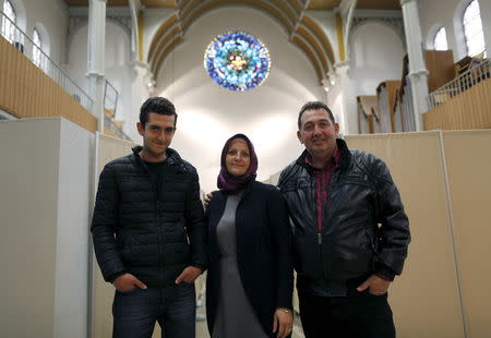 Members of a migrant Syrian family, Zabyl Olabi (C), her husband Mahmod and their 18-year-old son Humam (L), who came from Haleb near Aleppo, pose inside a Protestant church in Oberhausen, Germany November 19, 2015. REUTERS/Ina Fassbender