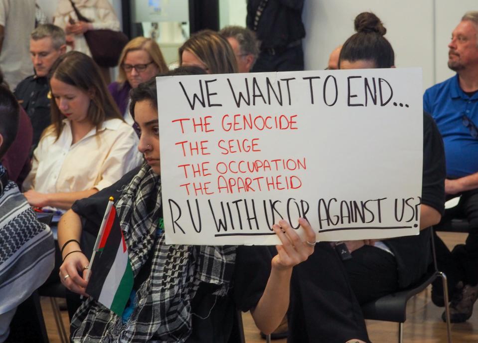 Pro-Palestinian protesters hold signs calling for the West Lafayette City Council to approve a resolution that supports a ceasefire in the Middle East, at West Lafayette's March City Council meeting, on Monday, March 4, 2024, in West Lafayette, Ind.