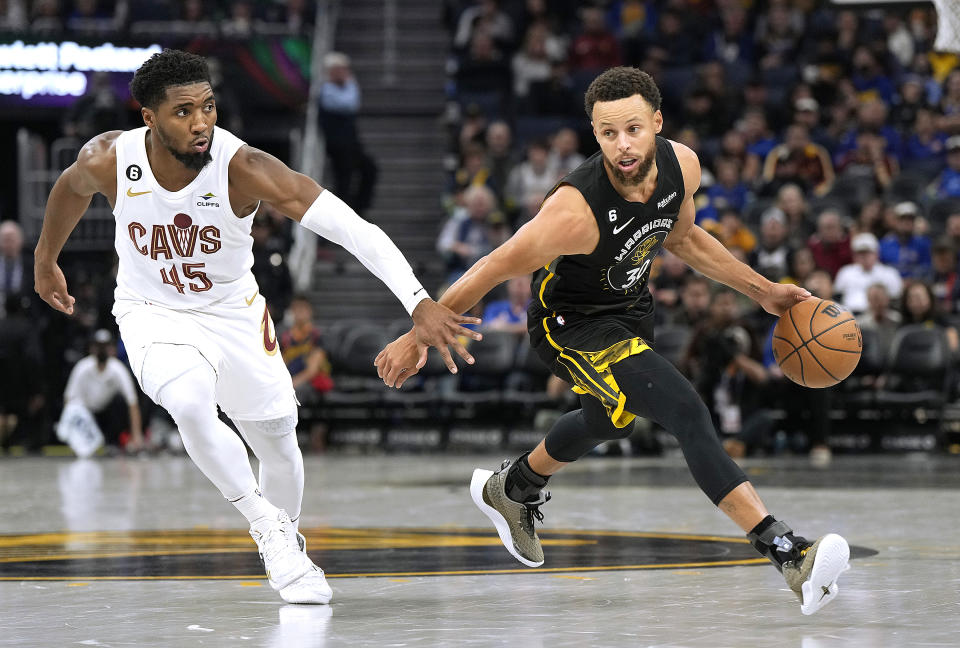 SAN FRANCISCO, CALIFORNIA - NOVEMBER 11: Stephen Curry #30 of the Golden State Warriors dribbles the ball past Donovan Mitchell #45 of the Cleveland Cavaliers in the third of an NBA basketball game at Chase Center on November 11, 2022 in San Francisco, California. NOTE TO USER: User expressly acknowledges and agrees that, by downloading and or using this photograph, User is consenting to the terms and conditions of the Getty Images License Agreement. (Photo by Thearon W. Henderson/Getty Images)