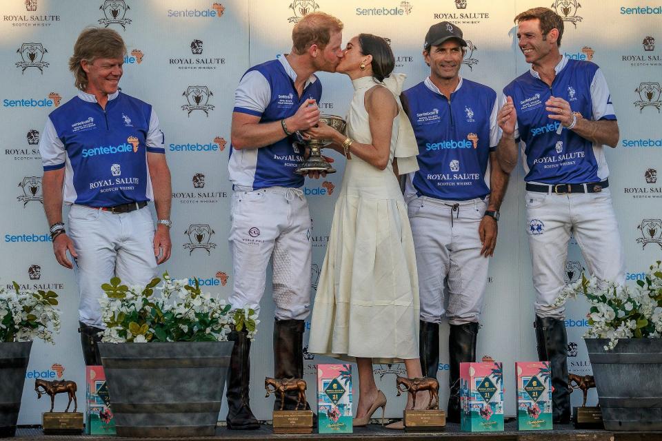 Duchess of Sussex Meghan Markle and Prince Harry, Duke of Sussex share a kiss after she presented him and his team with the champions trophy after a polo play at Grand Champions Polo in Wellington on April 12, 2024.