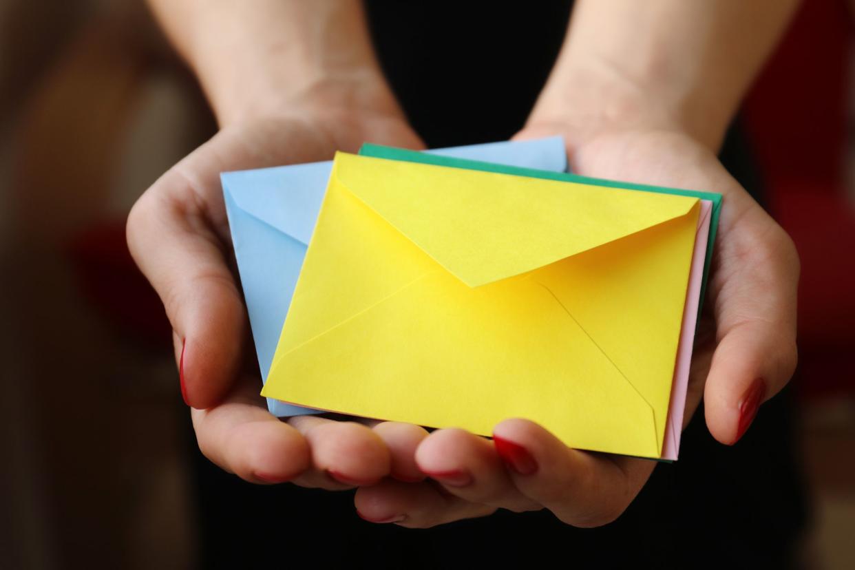 Woman's hand holding closed envelopes