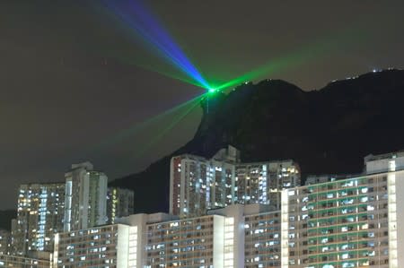 Anti-extradition bill protesters use laser beams as they form a human chain on top of the iconic Lion Rock, at Wong Tai Sin, during mid-autumn festival in Hong Kong