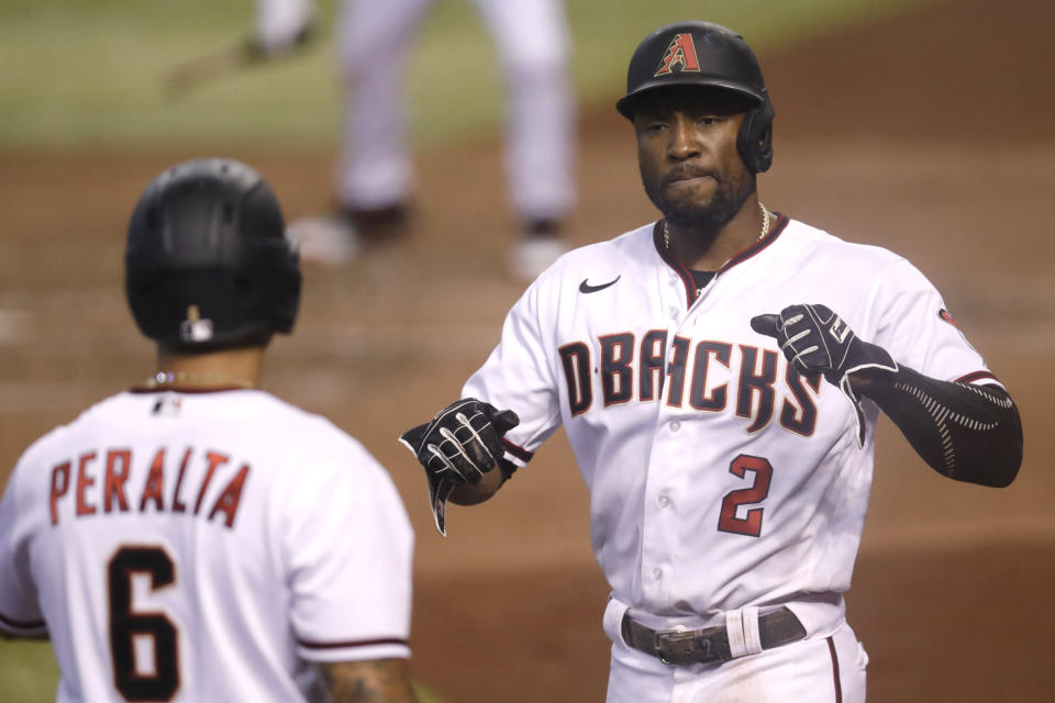 Arizona Diamondbacks' Starling Marte (2) celebrates scoring on a double by Christian Walker with teammate David Peralta (6) during the sixth inning of a baseball game against the Houston Astros Thursday, Aug. 6, 2020, in Phoenix. (AP Photo/Matt York)