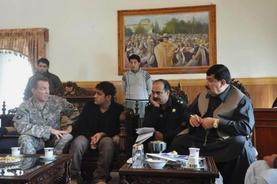 In this 2010 photo provided by U.S. Army Capt. Matthew Ball shows his interpreter Qismat Amin, second seated from left, in Jalalabad, the capital of Nangarhar province of Afghanistan. Amin, who has been living in hiding after getting threats from Taliban and Islamic state fighters, got his visa Sunday, Jan. 29, 2017, after nearly four years of interviews. Ball bought him a $1,000 plane ticket to San Francisco and plans to meet him at the airport with an attorney. Ball said he has bought a plane ticket for his Afghan translator in case that country is added to the list of banned nations. ( U.S. Army Capt. Matthew Ball via AP)