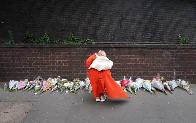 A woman lays flowers near the scene in Croydon