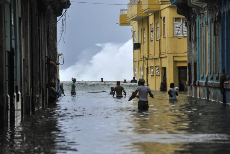 Cubans wade through a flooded street near the Malecon seafront promenade in Havana, on September 10, 2017