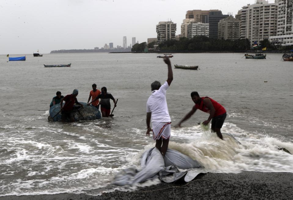 Fishermen pull their nets out of the Arabian Sea in Mumbai, India, Wednesday, June 3, 2020. A storm in the Arabian Sea off India's west coast intensified into a severe cyclone on Wednesday, gathering speed as it barreled toward India's financial capital of Mumbai. Nisarga was forecast to drop heavy rains and winds gusting up to 120 kilometers (75 miles) per hour when it makes landfall Wednesday afternoon as a category 4 cyclone near the coastal city of Alibagh, about 98 kilometers (60 miles) south of Mumbai, India's Meteorological Department said. (AP Photo/Rajanish Kakade)