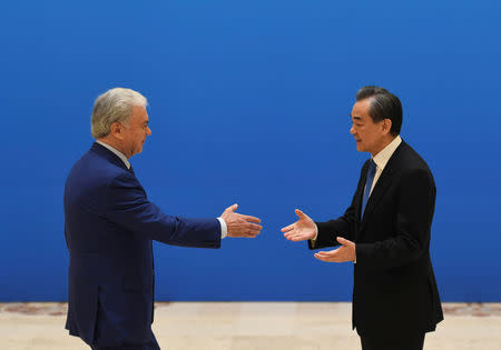 SCO Secretary-General Rashid Alimov (left) shakes hands with Chinese State Councilor and Foreign Minister Wang Yi before a meeting of foreign ministers and officials of the Shanghai Cooperation Organisation (SCO) at the Diaoyutai State Guest House in Beijing, China, April 24, 2018. MADOKA IKEGAMI/Pool via REUTERS