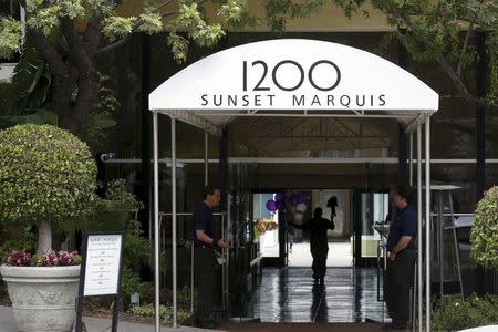 A man carries flowers into the Sunset Marquis hotel where U2 tour manager Dennis Sheehan was pronounced dead in his hotel room, according to local media, in West Hollywood, California May 27, 2015. REUTERS/Patrick T. Fallon