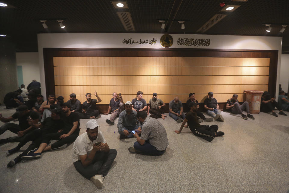 Iraqi protesters rest in the Parliament building in Baghdad, Iraq, Saturday, July 30, 2022 as thousands of followers of an influential Shiite cleric breached the building for the second time in a week to protest the government formation efforts lead by Iran-backed groups. Heeding the calls of cleric Muqtada al-Sadr, the demonstrators used ropes to pull down cement barricades leading to the gate of Iraq’s Green Zone. The district houses official buildings and foreign embassies. (AP Photo/Anmar Khalil)
