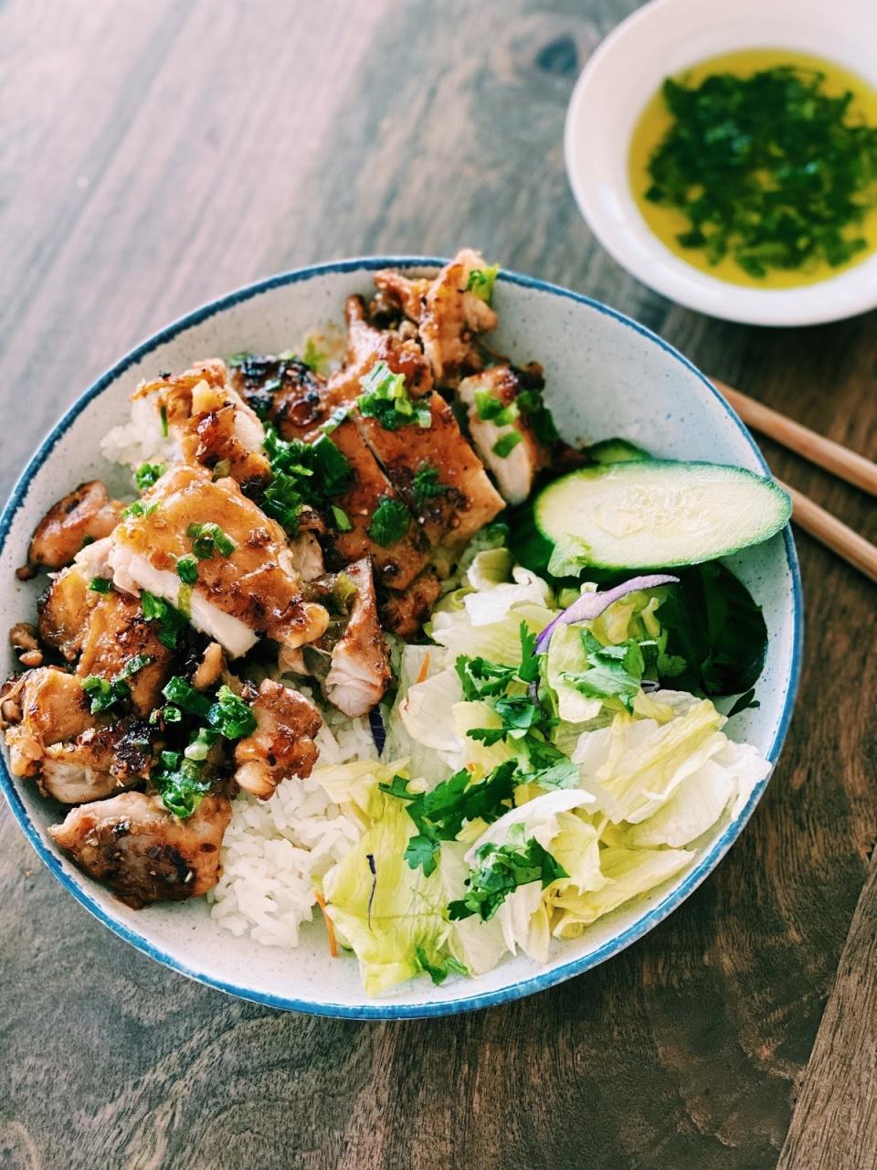 A rice bowl with chicken, cabbage, and scallion oil.