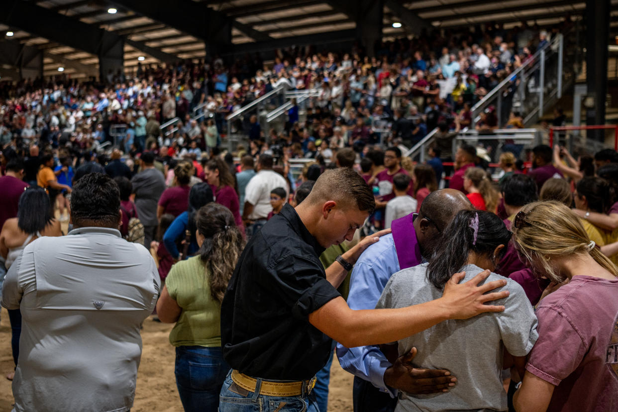 Community members pray together at a vigil for the 21 victims of the mass shooting in Uvalde, Texas