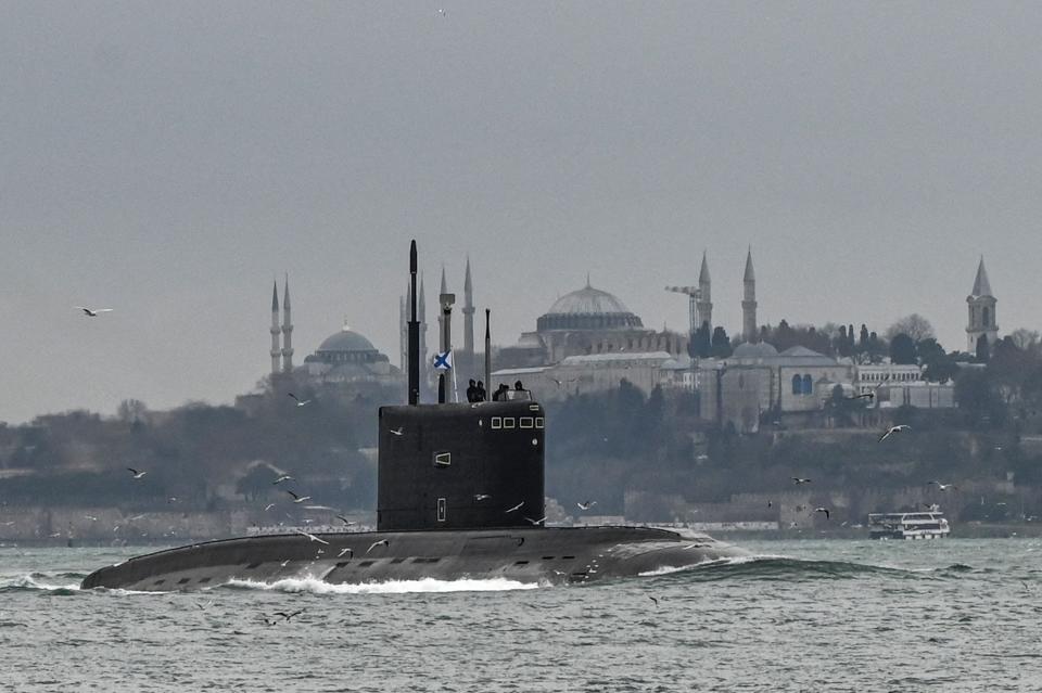 Russian Navy's diesel-electric Kilo class submarine Rostov-on-Don sails with an naval ensign of the Russian Federation, also known in Russian as The Andreyevsky Flag on it through the Bosphorus Strait on the way to the Black Sea past the city Istanbul as Sultanahmet mosque (L) and Hagia Sophia mosque (R) are seen in the backround on February 13, 2022.