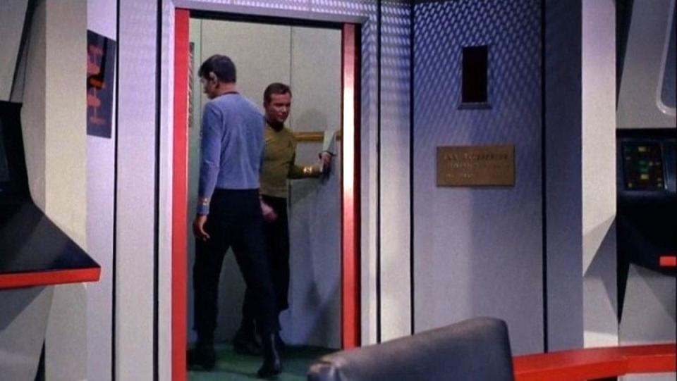 Captain Kirk and Spock walk into a turbolift on Star Trek The Original Series