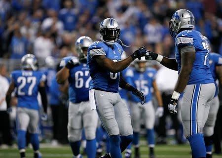 Dec 14, 2014; Detroit, MI, USA; Detroit Lions wide receiver Calvin Johnson (81) bumps fists with tackle Cornelius Lucas (77) during the fourth quarter against the Minnesota Vikings at Ford Field. Lions win 16-14. Mandatory Credit: Raj Mehta-USA TODAY Sports