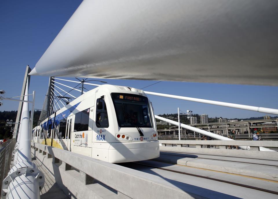 The first light rail train carrying passengers crosses the newly opened Tilikum Crossing, a unique bridge, in Portland, Ore., Saturday, Sept. 12, 2015. The Tilikum Crossing joins 11 other Portland bridges across the Willamette River, which divides the city. One of its features are lights whose colors change with the seasons. | Timothy J. Gonzalez, Associated Press
