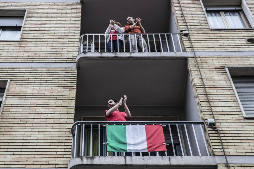 People applaud from balconies in front of the house of 23-year-old Italian volunteer Silvia Costanza Romano, in Milan, Italy, Sunday, May, 10, 2020. An Italian aid worker who was kidnapped in Kenya in late 2018 has been freed in Somalia. Italian Premier Giuseppe Conte on Saturday hailed the release of Silvia Romano, who was a 23-year-old volunteer with the humanitarian group Africa Milele when she was abducted in the coastal trading center of Chakama. (AP Photo/Luca Bruno)